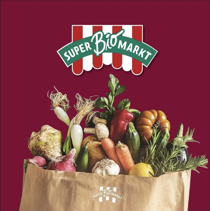 SuperBioMarkt-Logo über einer Papiertüte voller frischem Gemüse
