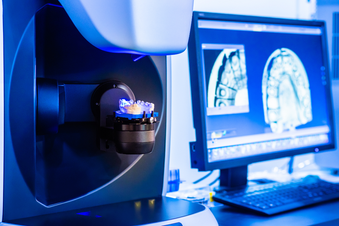3D dental scanner capturing a model of teeth with dental imaging displayed on a computer screen.