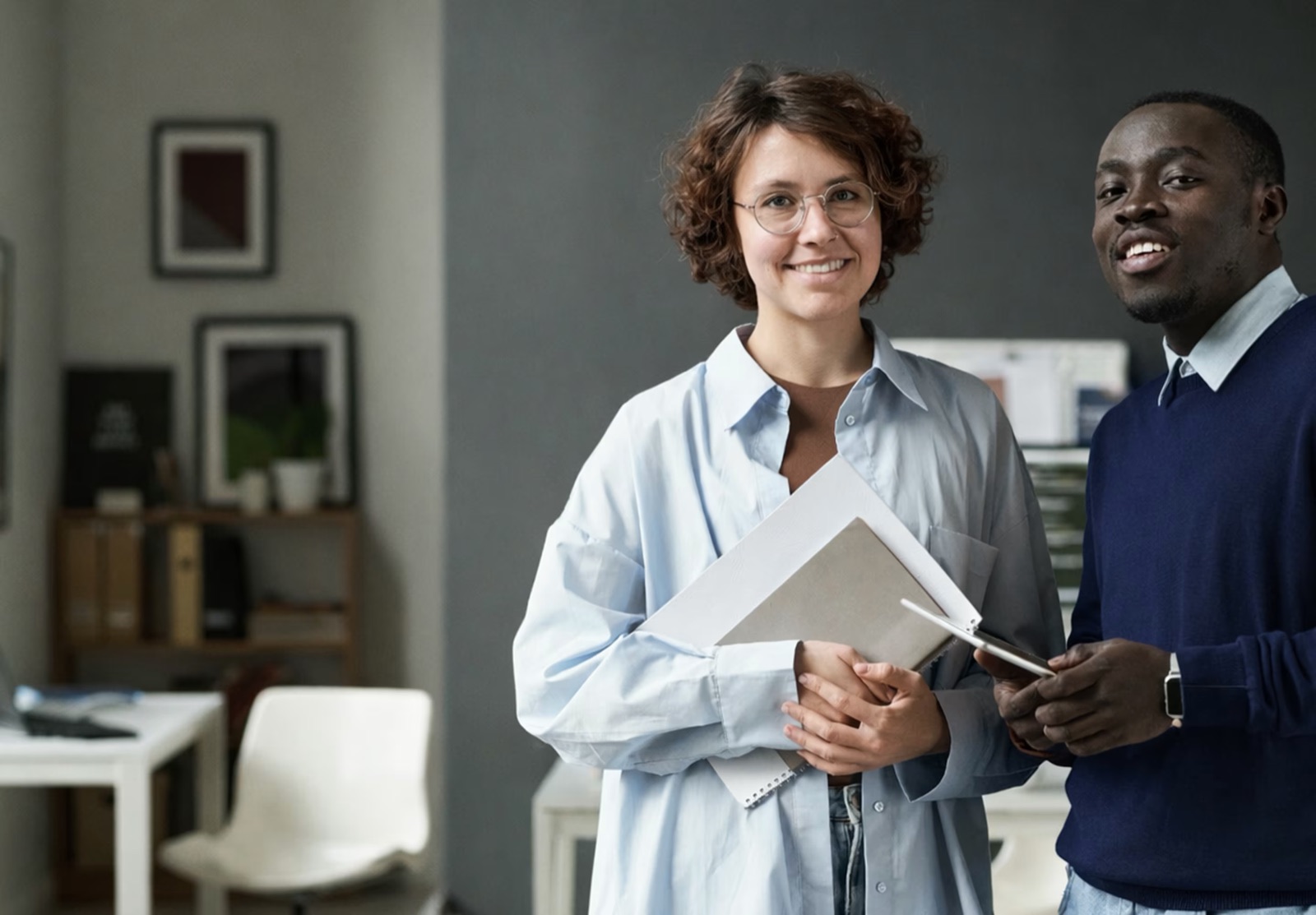 Two office colleagues with documents and a tablet, planning workplace first aid cover