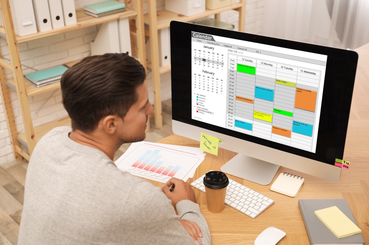 Employee using a calendar and time-tracking app on an office computer