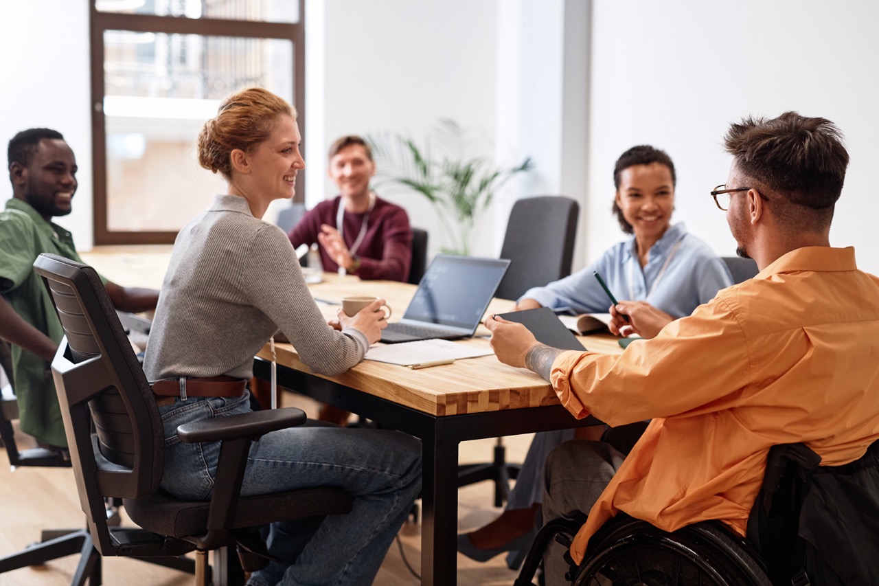 Business team collaborating around a meeting table on payroll add-on services