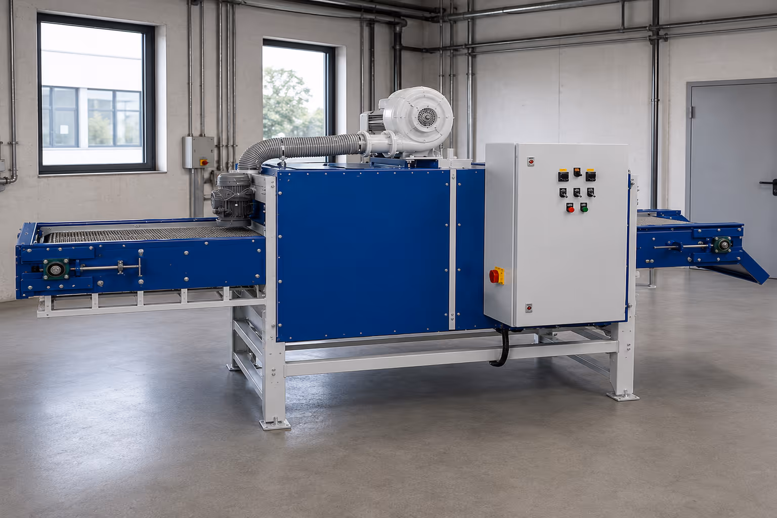 Blauer industrieller Durchlauftrockner mit Förderband und Steuerkasten in heller Fabrikumgebung.