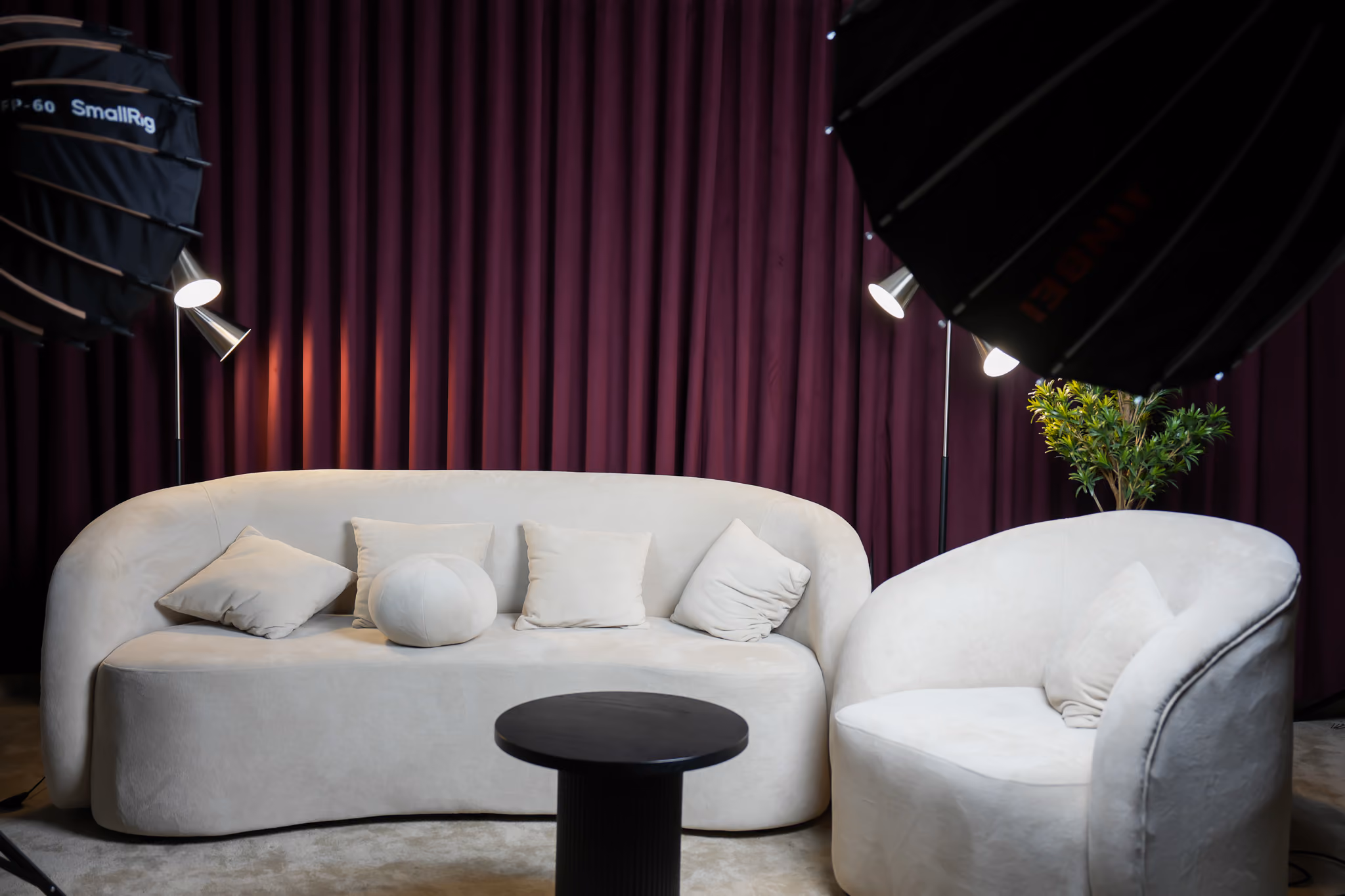 sofa podcast setup with maroon curtains in the background