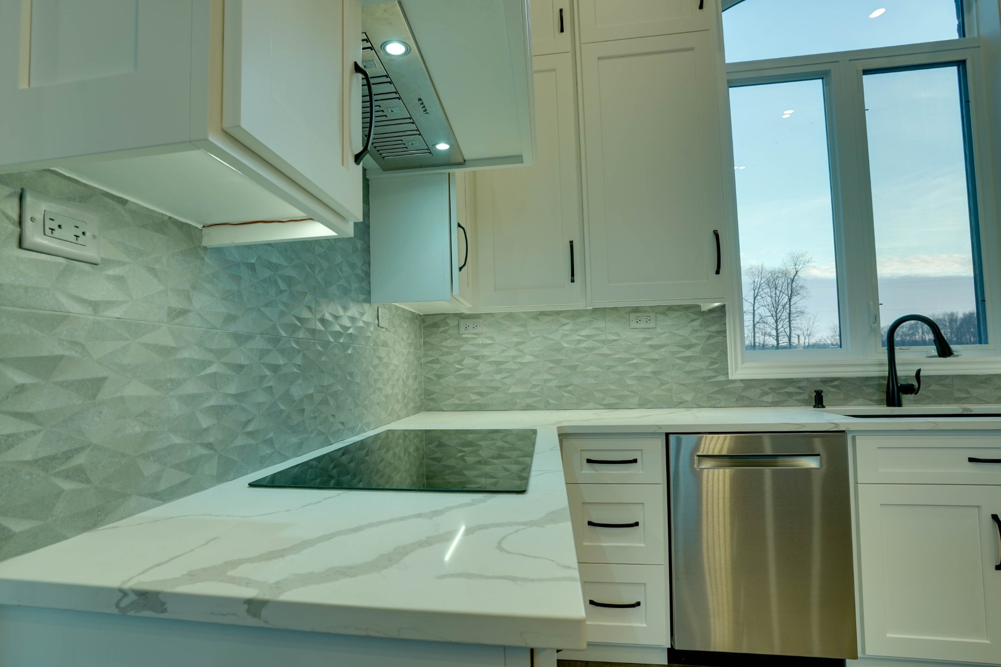 Quartz countertop edge and faceted tile backsplash macro detail