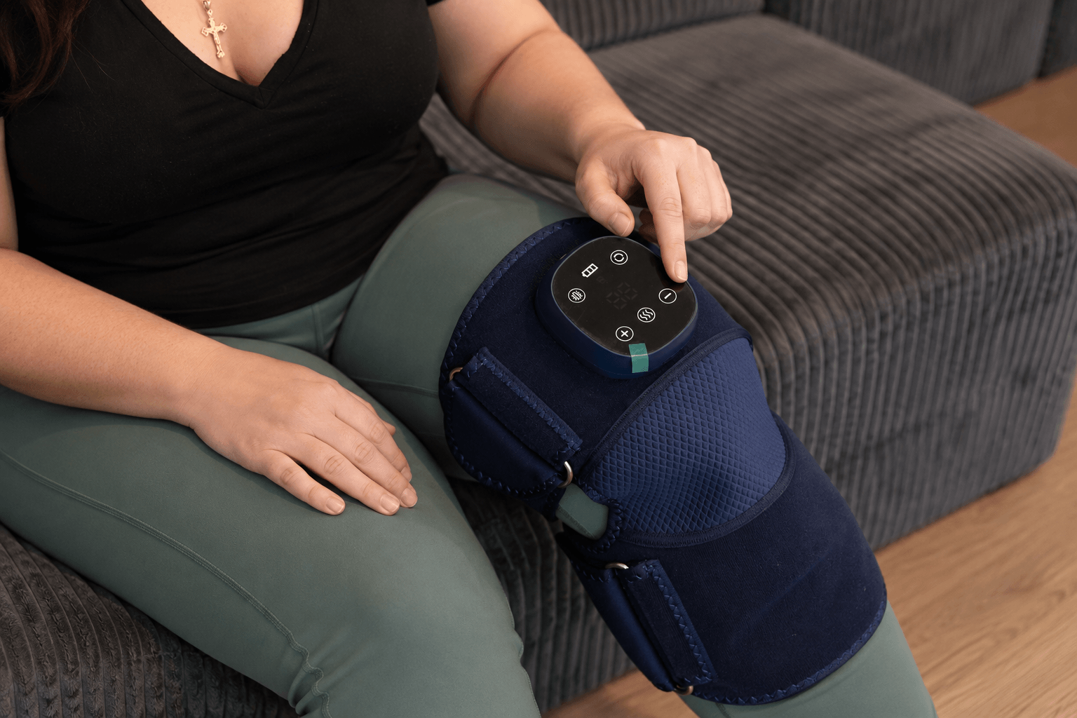 Close-up of a finger pressing the Oasis controller on the knee wrap