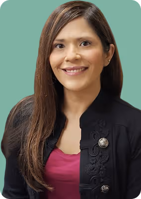 Smiling woman with long brown hair wearing a black jacket and magenta top against a green background.