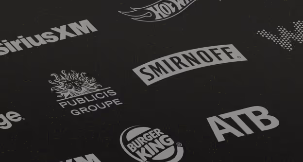 Collage of various logos on a dark background including SiriusXM, Hot Wheels, Smirnoff, Publicis Groupe, Burger King, and ATB.