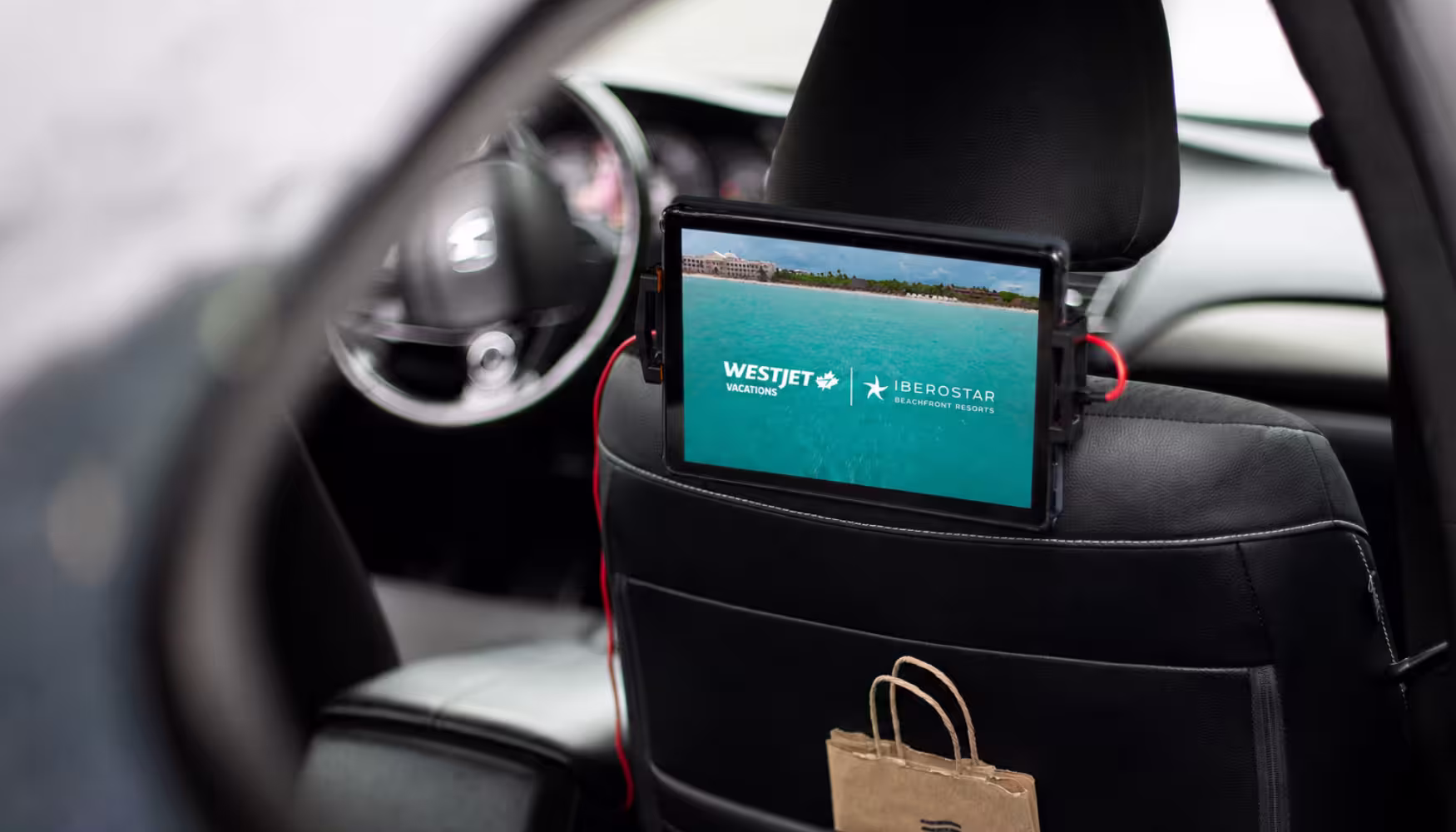 WestJet & Iberostar ad on tablet inside vehicle