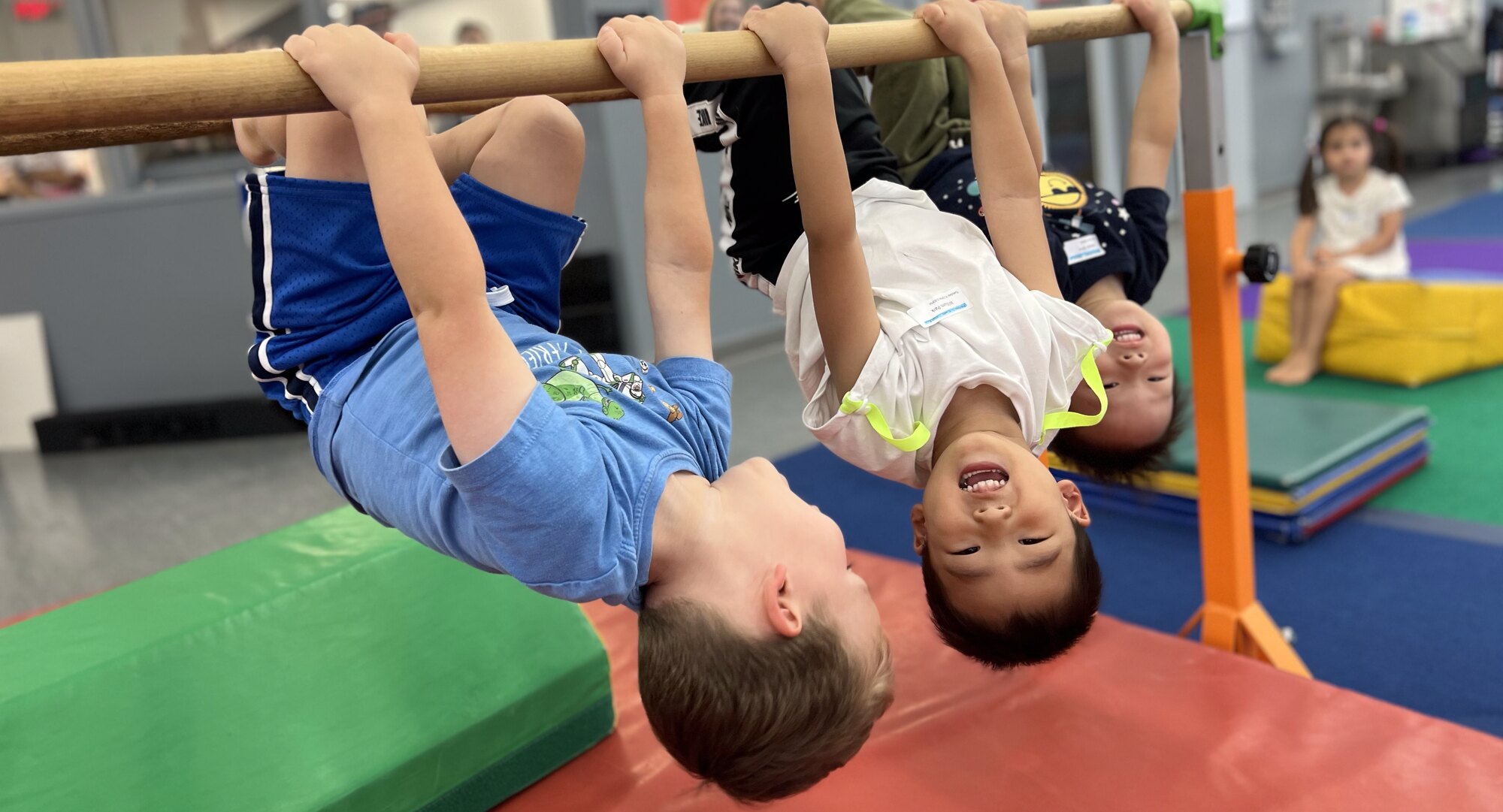 Kids hanging from a bar during GymFusion class at Dynamite Gymnastics in North Bethesda