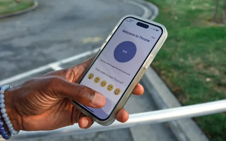 person holding a phone that shows the cleanliness rating screen in the throne mobile app