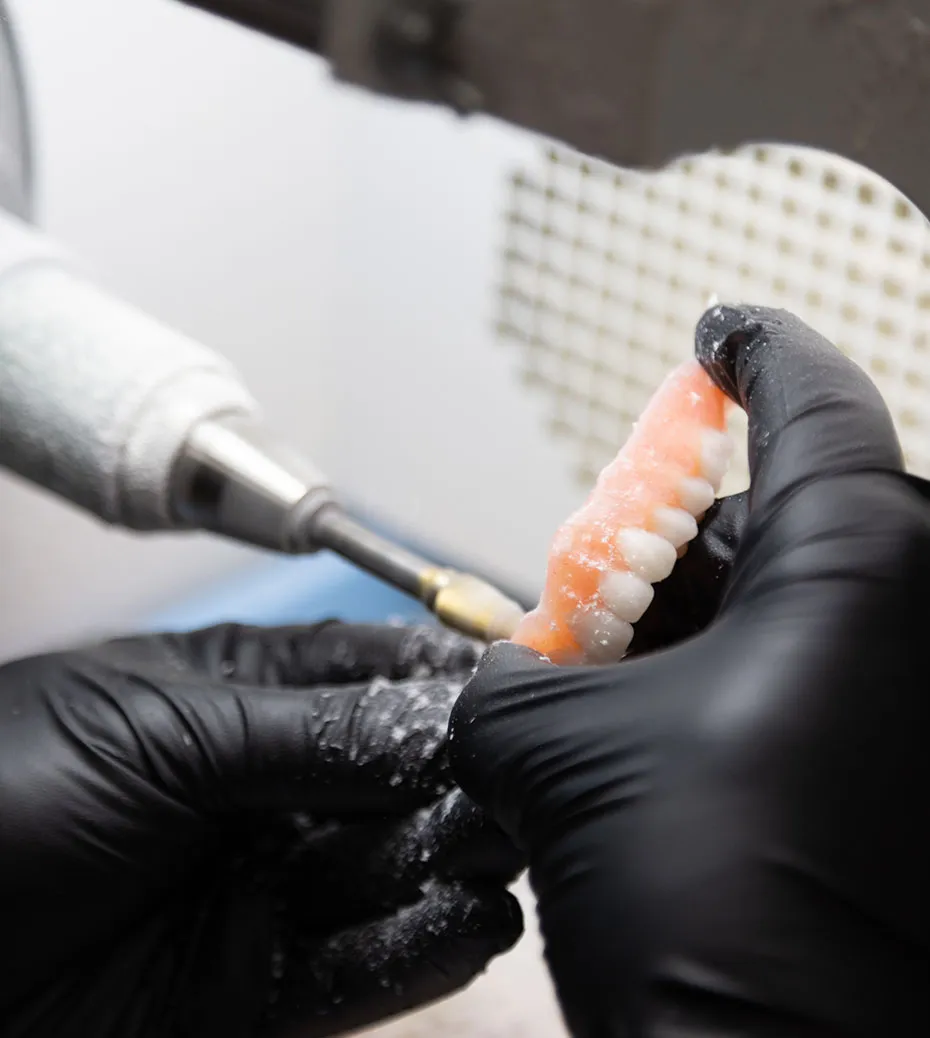 close up of a Secure Lab Technician shaping new custom dentures.