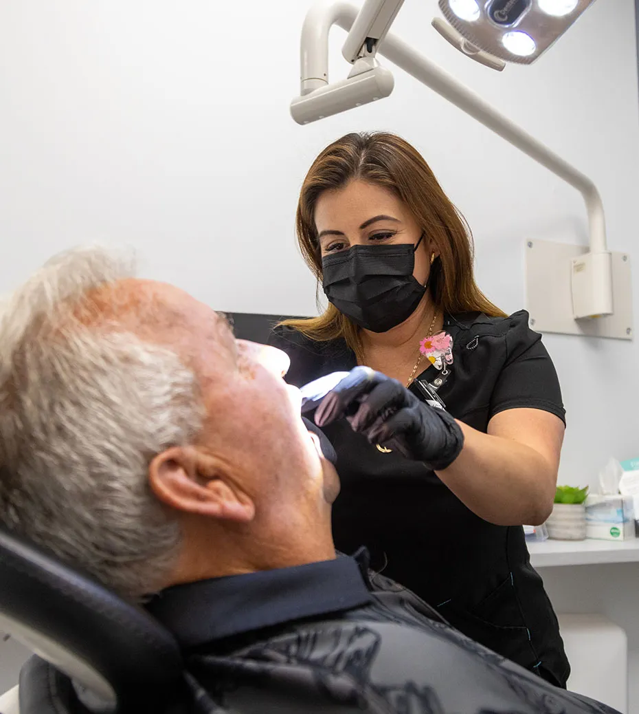 A Secure dentist examining a male patient.