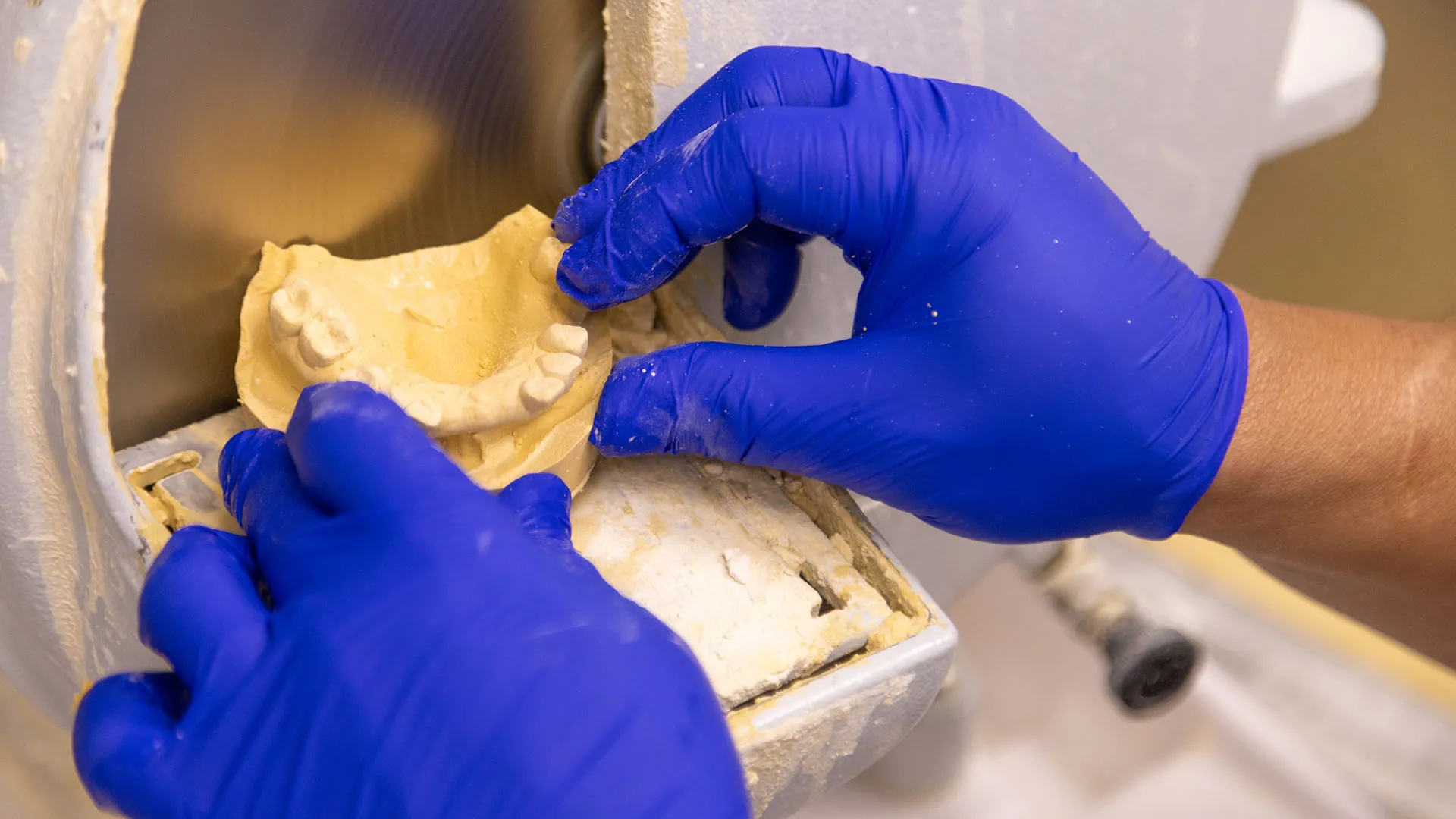 Detail photo of Secure lab technician shaping a mold.
