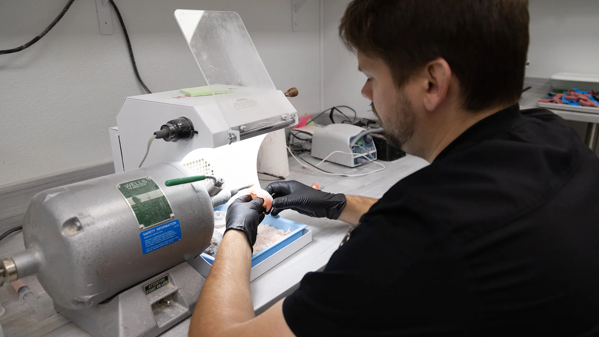 Secure Dentures and Implants Lab technician working on custom dentures.