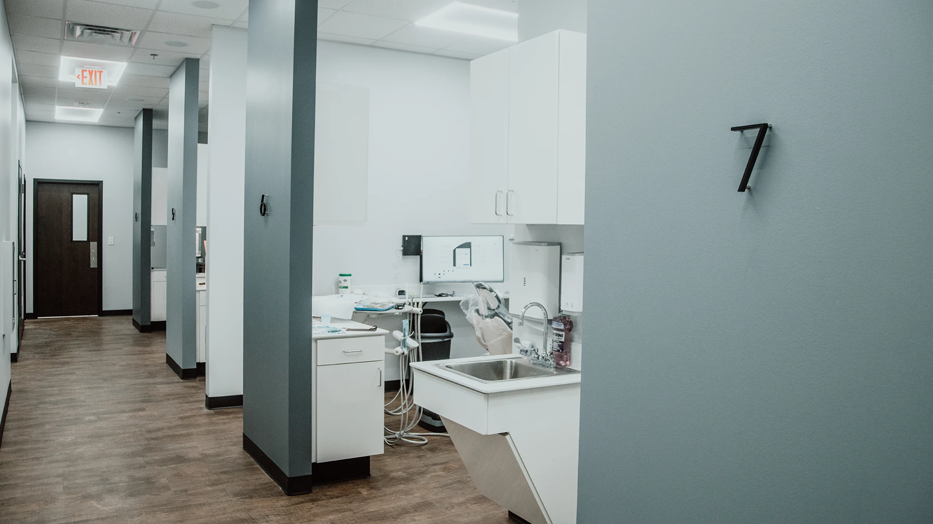 the hallway of a dentist office with multiple exam rooms.