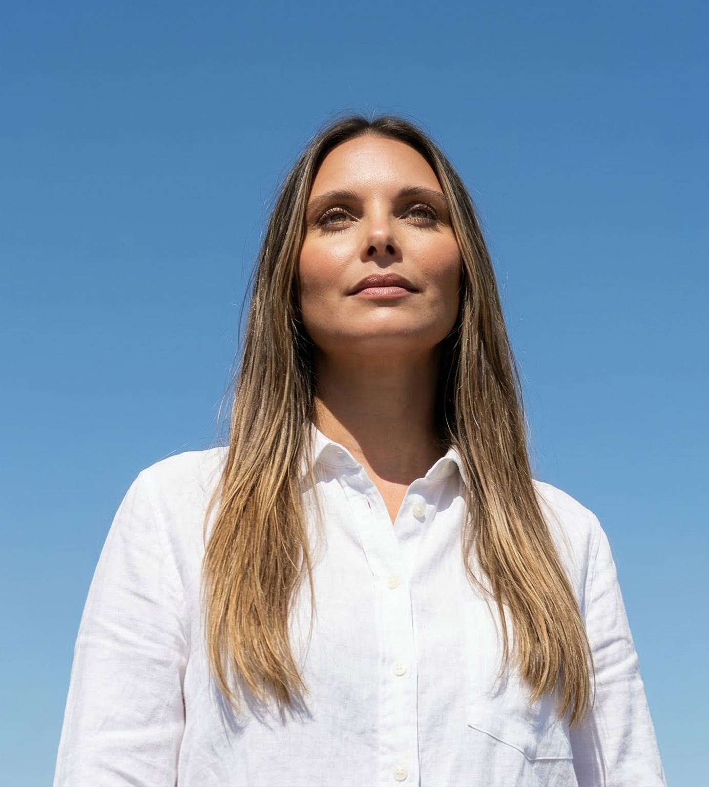 Portrait of a young man wearing an orange hat, viewed through a circular frame, with a thoughtful expression.