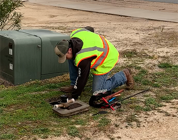 M&E Construction water meter installer working at a meter box