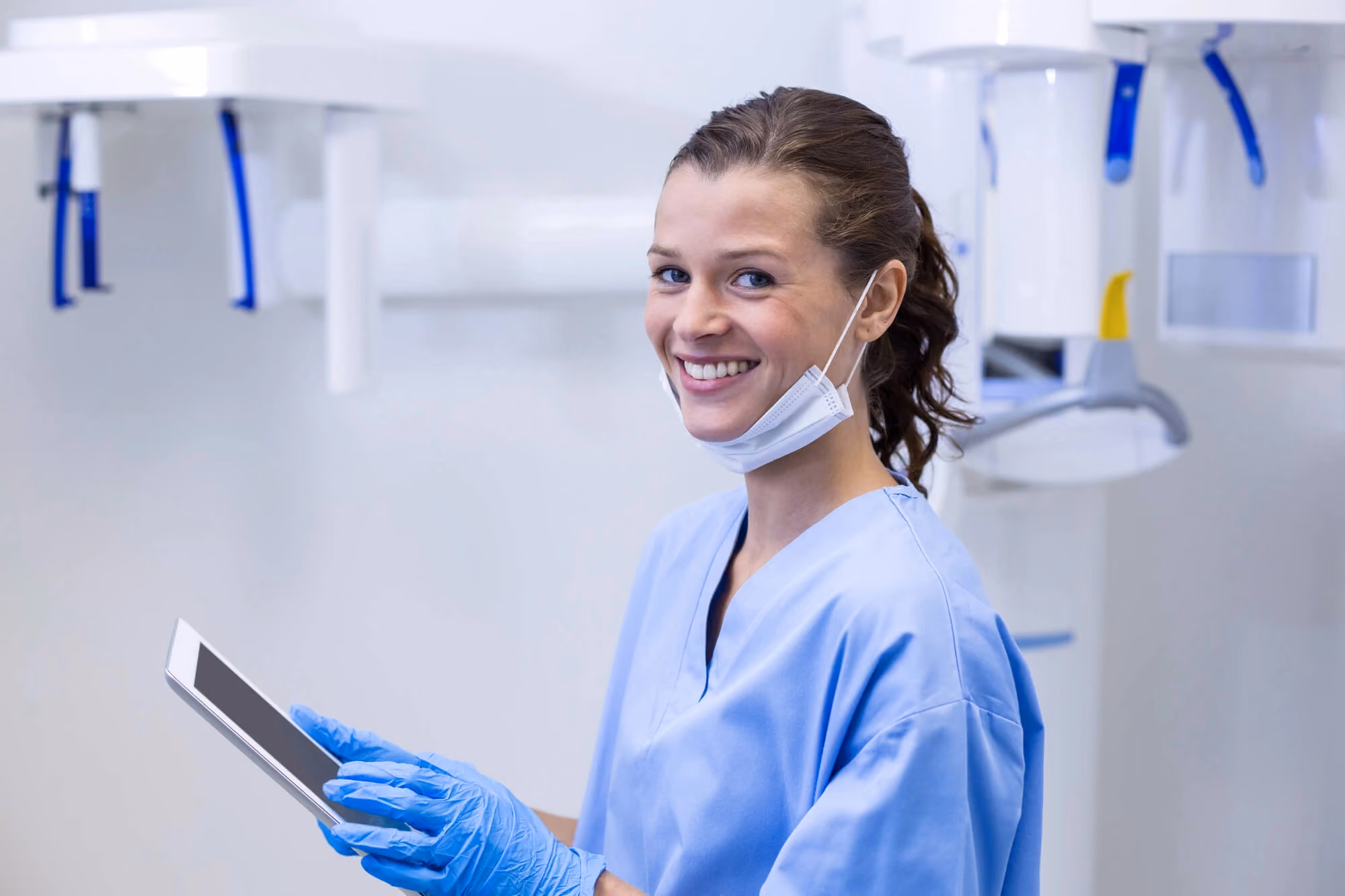 Female dentist smiling holding tablet