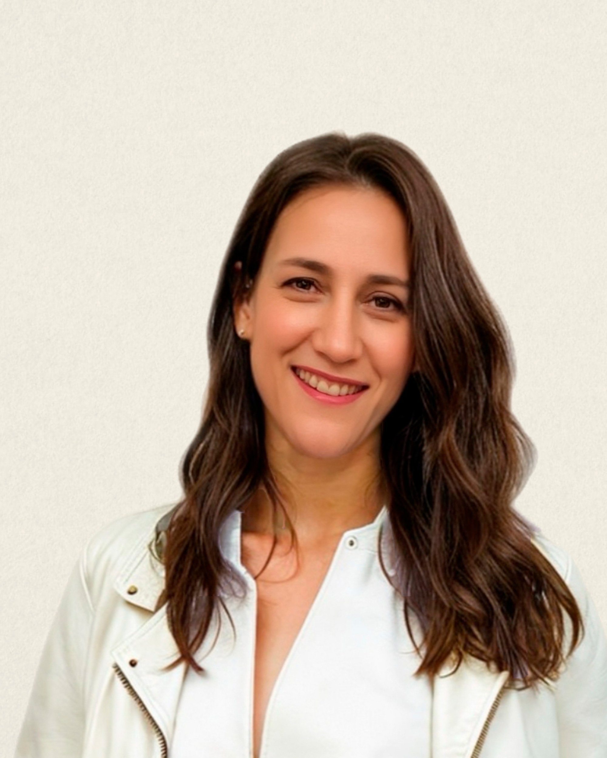 Woman wearing glasses and a pink and purple striped shirt smiling indoors.