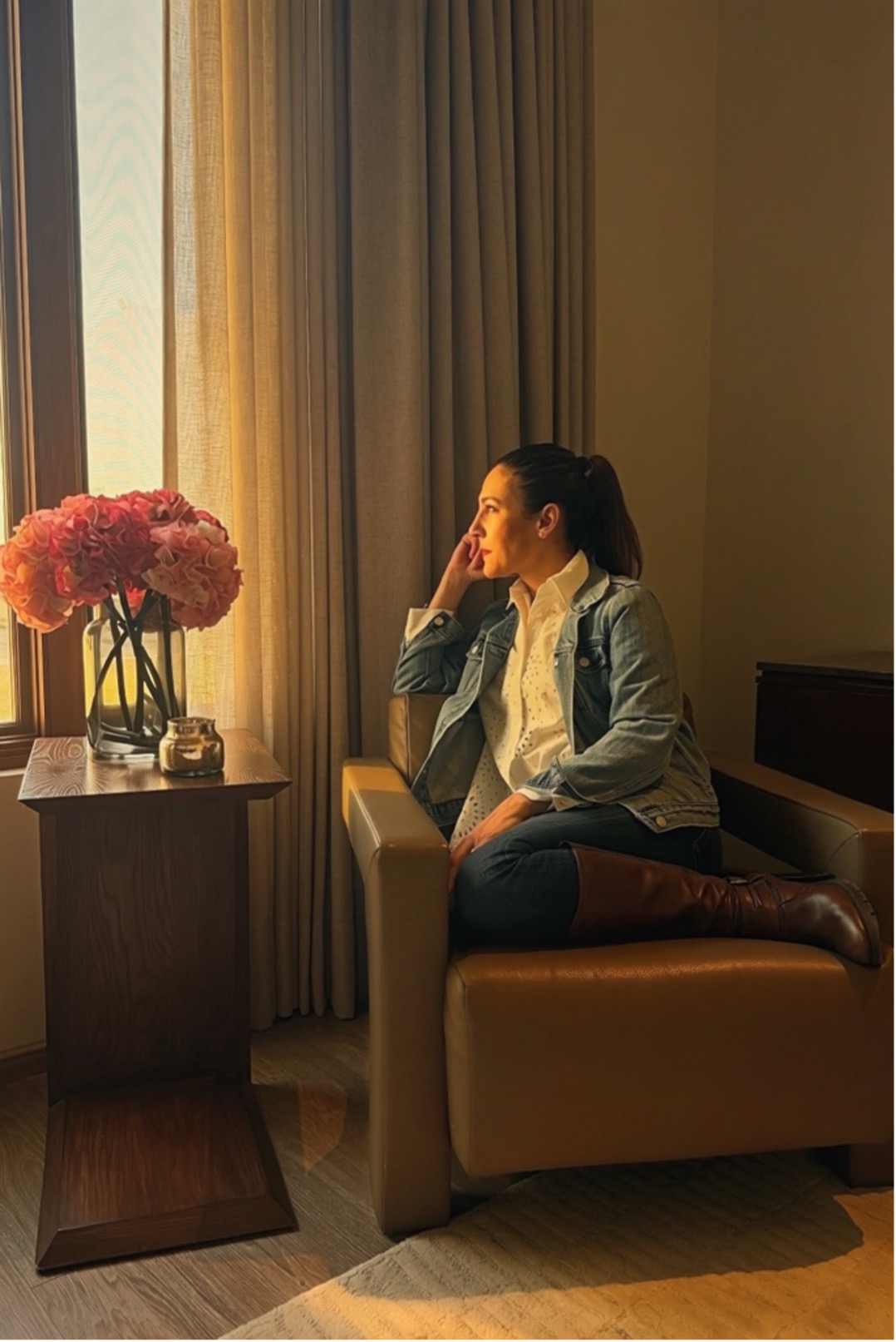 Woman wearing glasses and a pink and purple striped shirt smiling indoors.