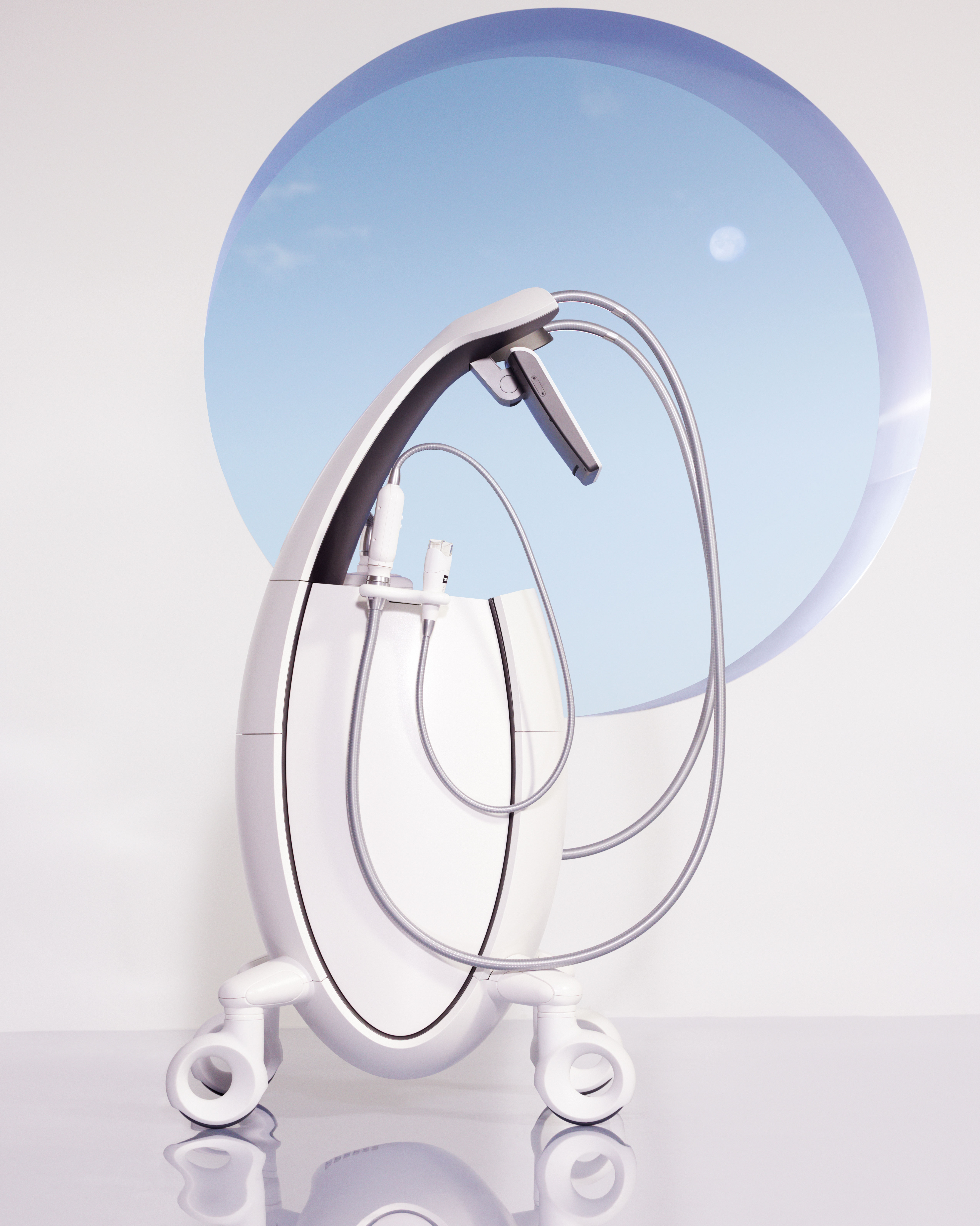 Modern white medical device with wheels and flexible tubes against a white wall with a circular blue window.