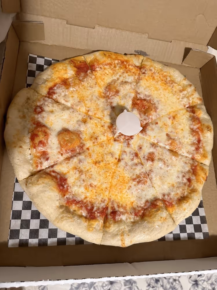 Cheese pizza cut into eight slices in a cardboard pizza box with a plastic pizza saver in the center.