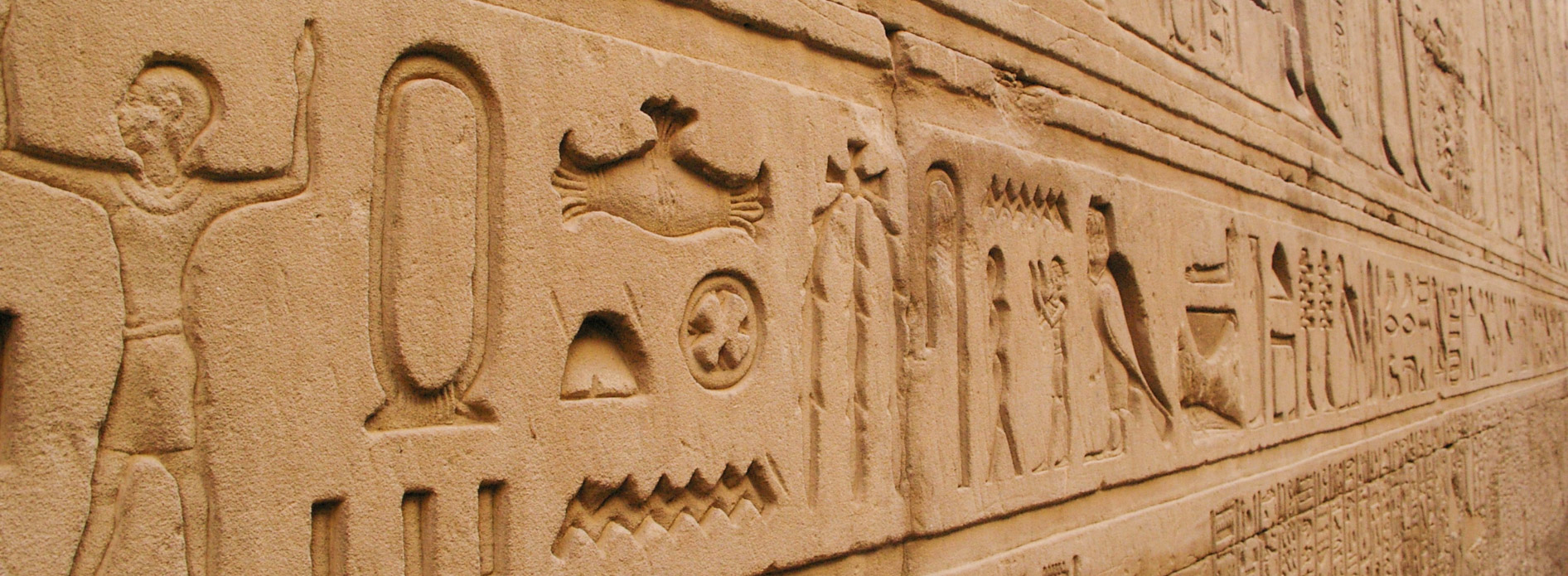 Hiéroglyphes égyptiens gravés sur un mur antique, symboles de l’écriture et de la civilisation pharaonique.