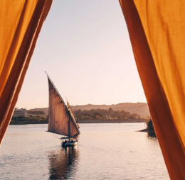 Navigation sur le Nil en dahabeyah avec au loin une felouque, paysages emblématiques de l’Égypte traditionnelle.