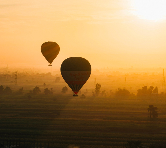 Vol en montgolfière au-dessus de Louxor, survolant temples et vallée du Nil, panorama emblématique de l’Égypte ancienne.