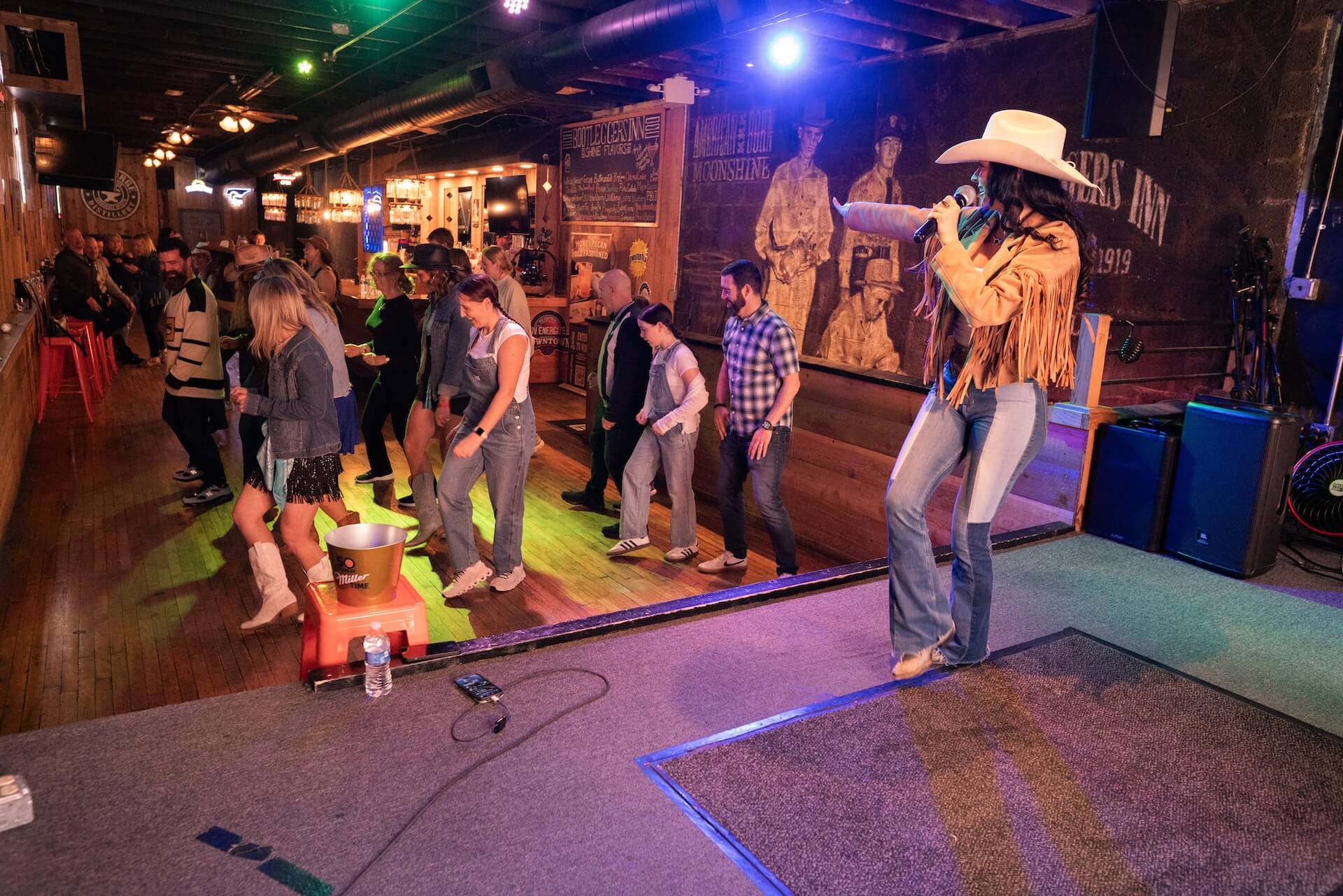 Country singer leading a line-dancing crowd img