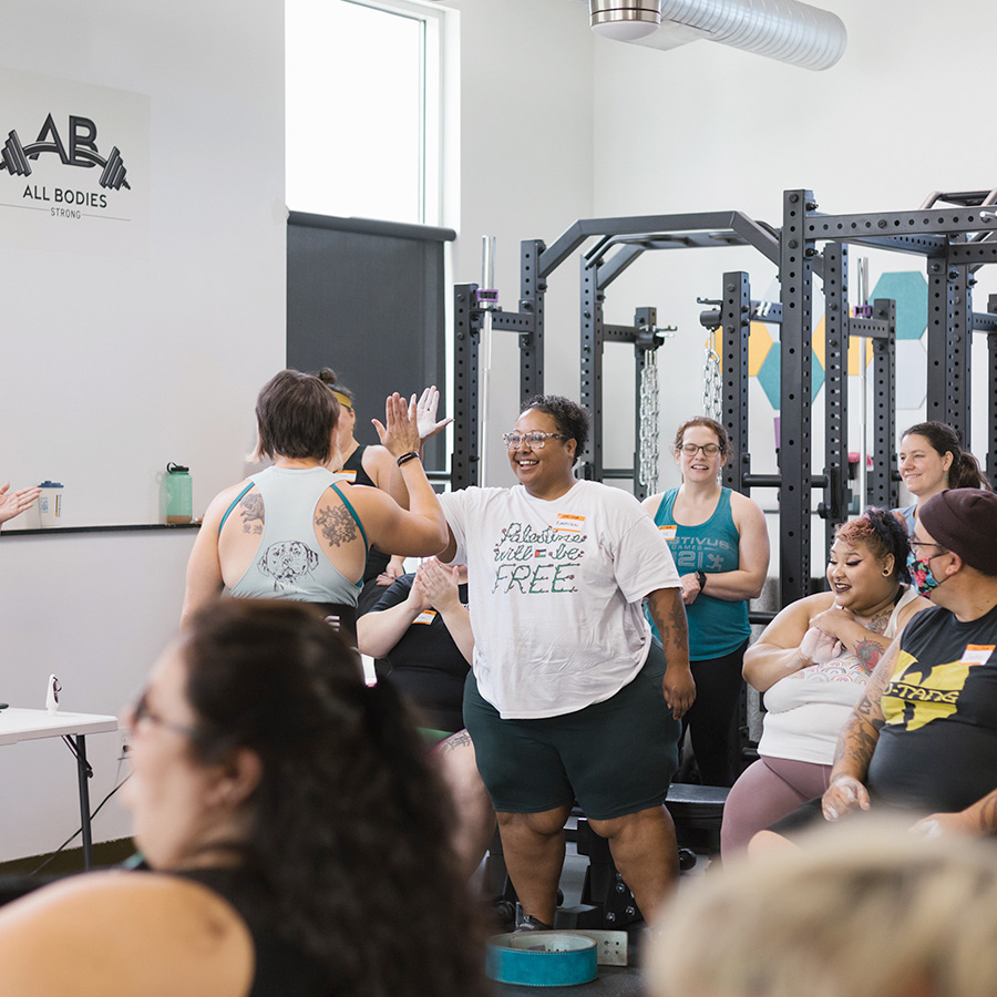 Two powerlifters high-fiving during a meet.