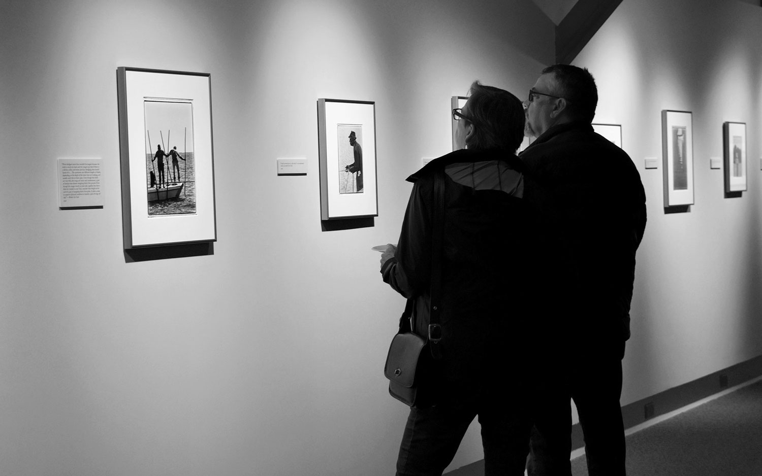 man and woman viewing photographs in an exhibition