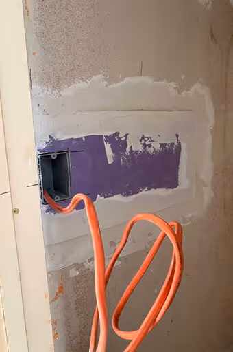 Drywall patch with an electrical box and wire during wall repair - providing professional handyman services and home repairs in Simi Valley.