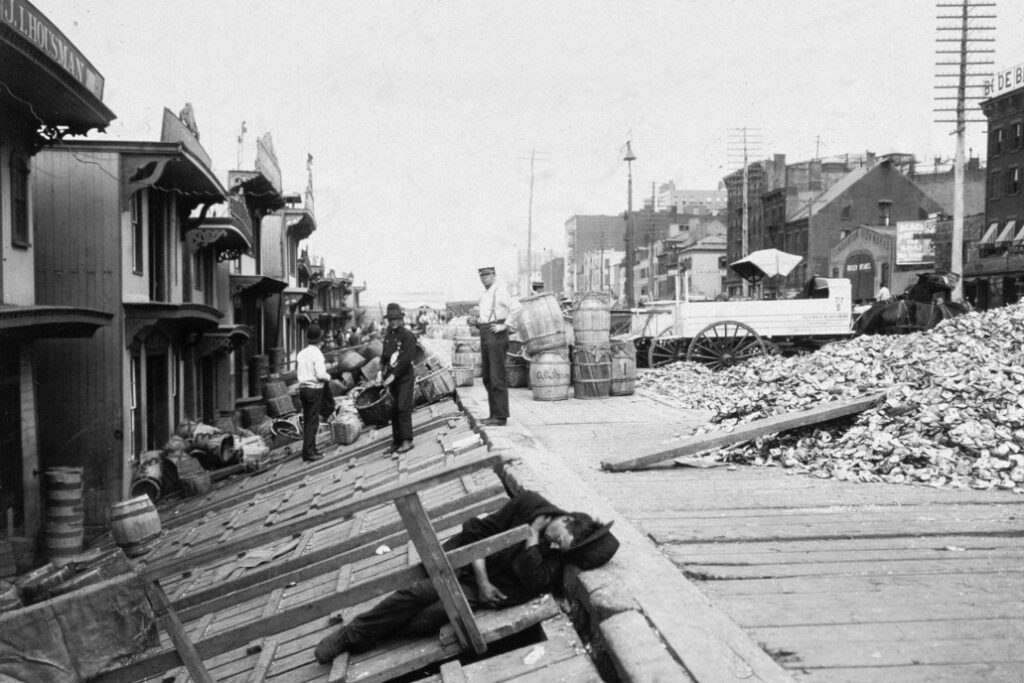 Historical photo of oyster barges and shell piles along the New York waterfront