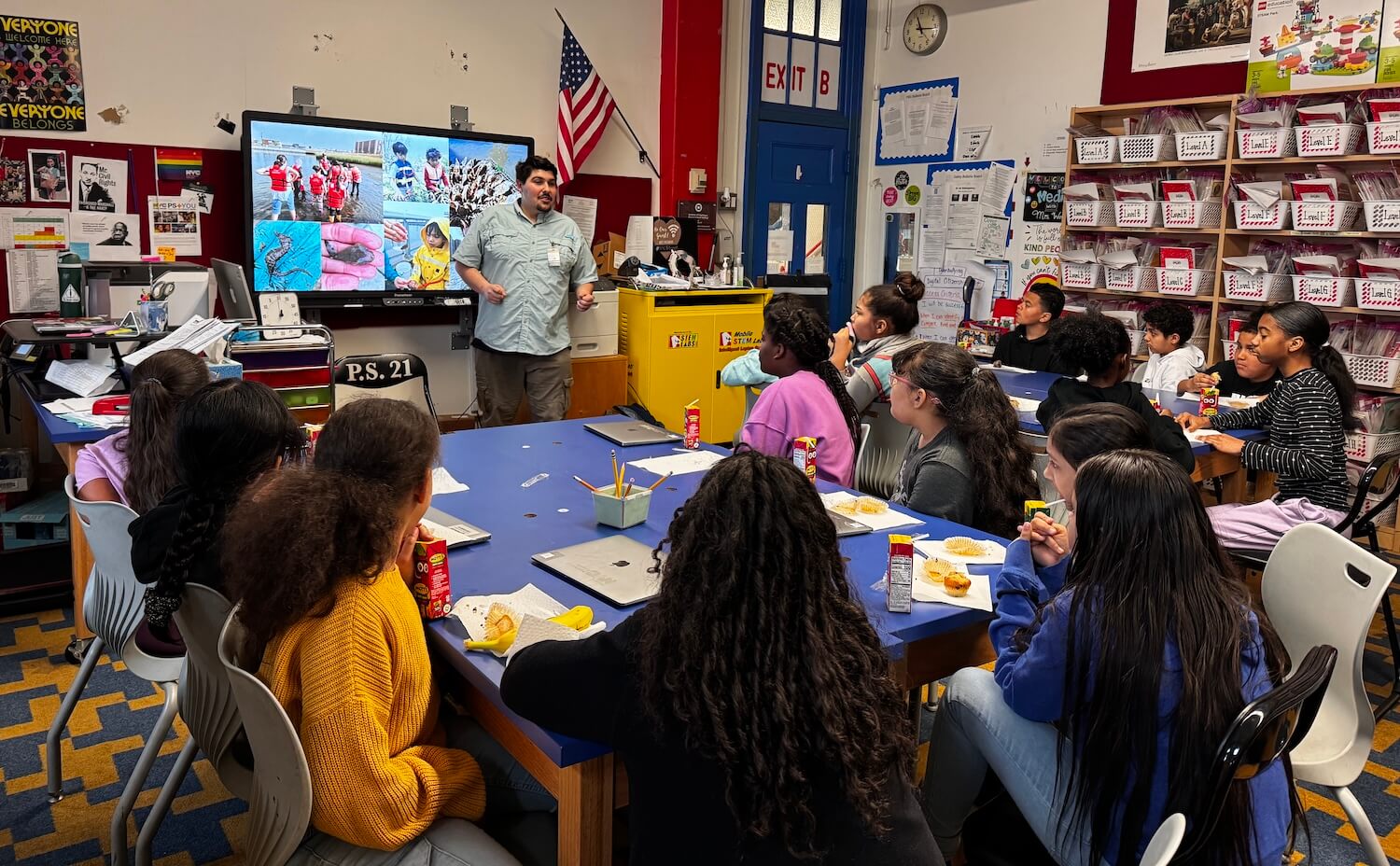 Educator sharing harbor field photos with middle school students in a classroom