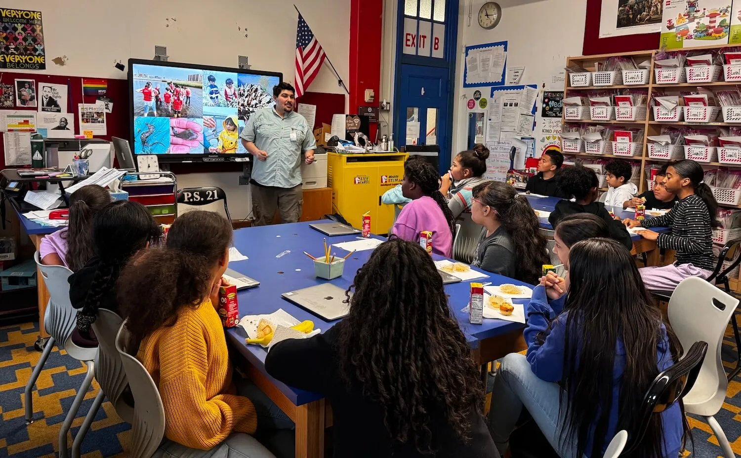Educator sharing harbor field photos with middle school students in a classroom