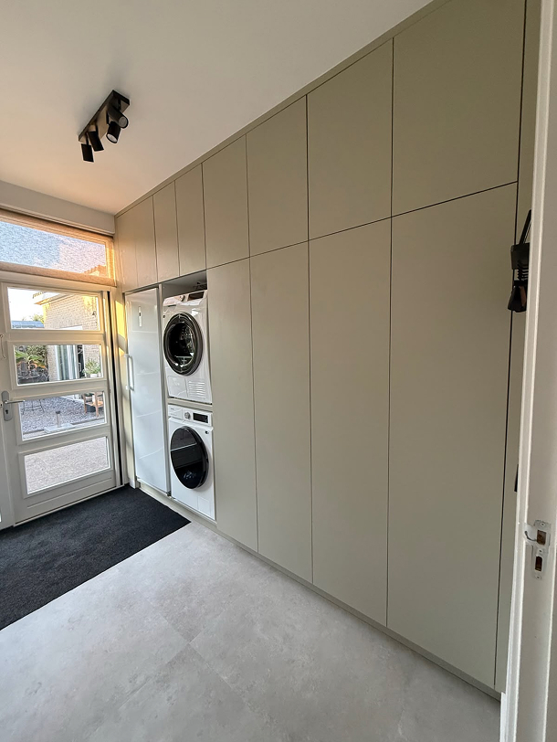 Maatwerk kast in de bijkeuken met ingebouwde wasmachine en droger