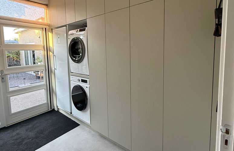 Maatwerk kast in de bijkeuken met ingebouwde wasmachine en droger