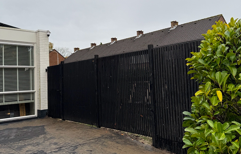 Houten schutting met poort en aangelegd straatwerk in Goes