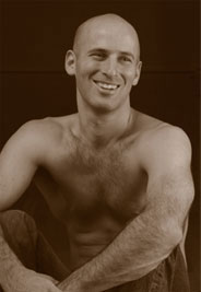 Bryan Kest seated in profile view with hands in prayer position and eyes closed, embodying deep meditative focus