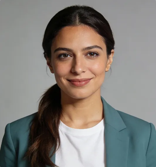 Smiling woman with dark hair tied back wearing a teal blazer and white shirt against a gray background.