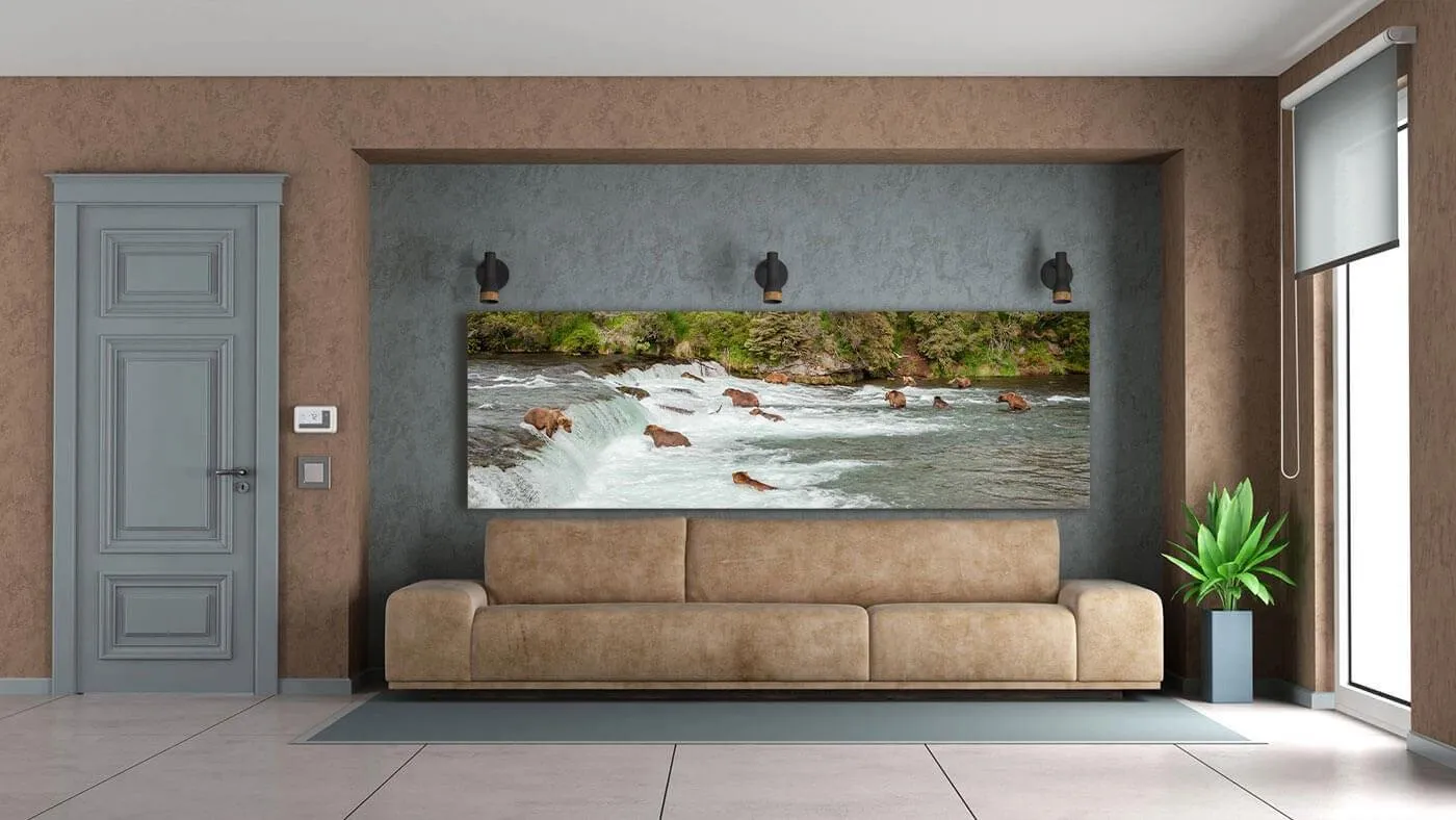 Modern living room with beige sofa, large nature-themed wall art showing bears fishing at a waterfall, and a potted plant near a window.
