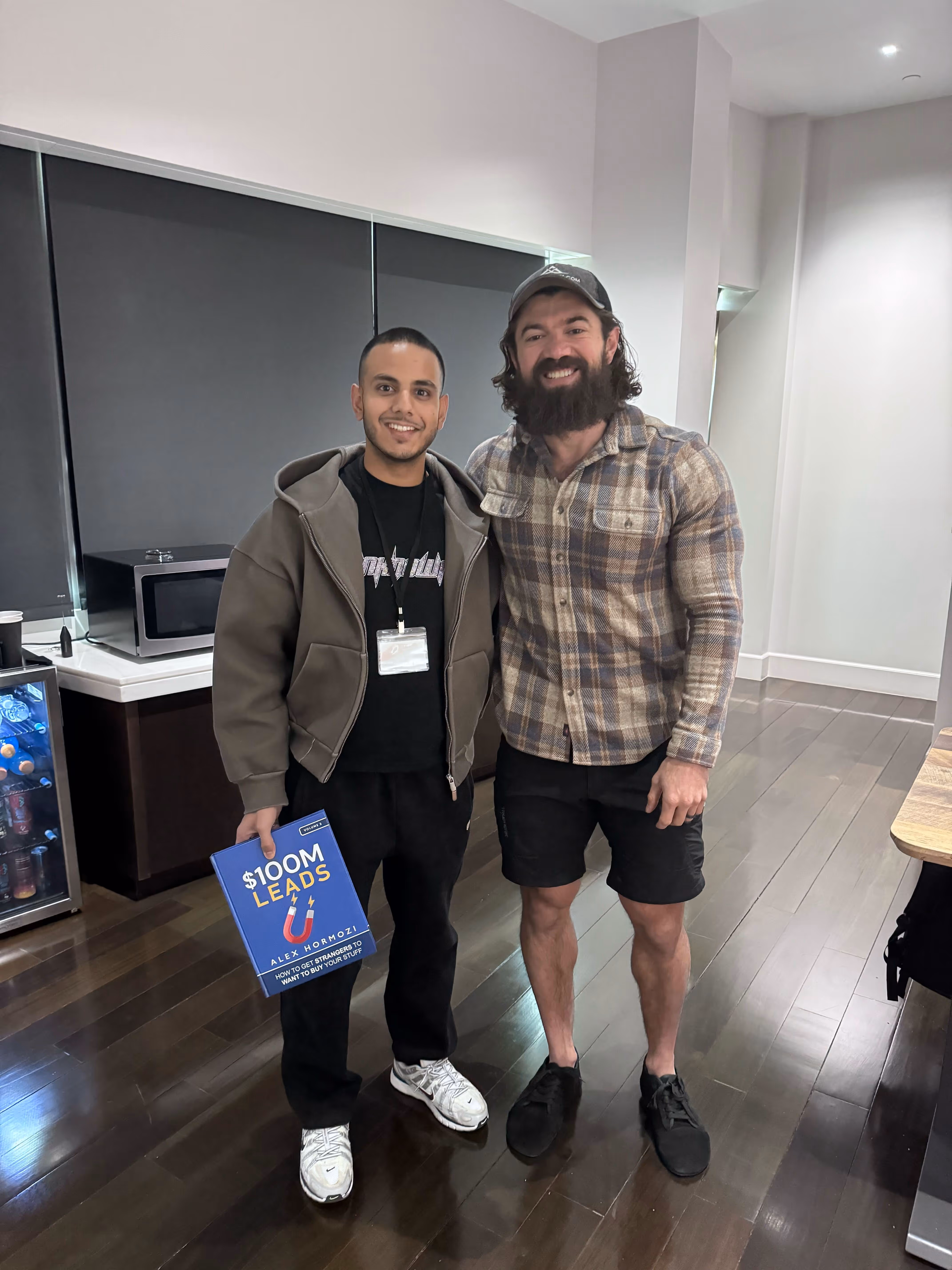 Ali of Stratus Digital standing with Alex Hormozi