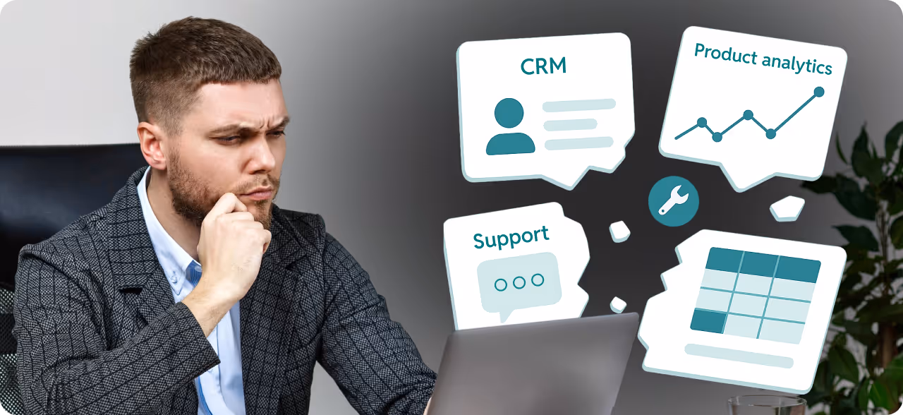 Man in a checkered jacket thoughtfully working on a laptop with floating icons labeled CRM, Product analytics, Support, and a table chart around him.