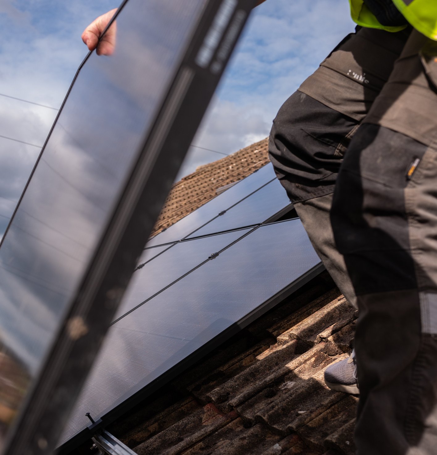 JellyWatt installer fitting solar panels on a roof