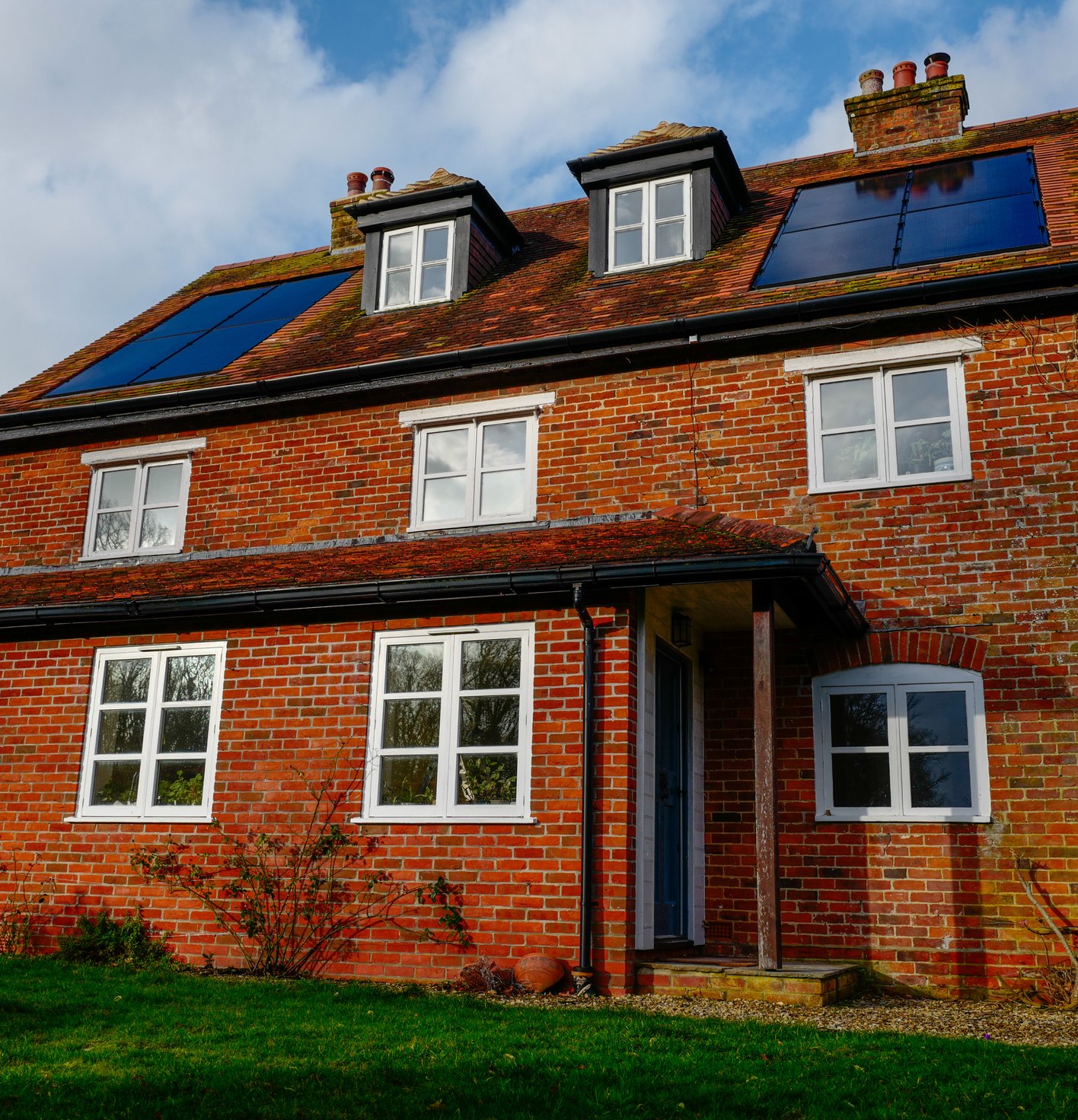 Solar panels on a red brick house, installed by JellyWatt