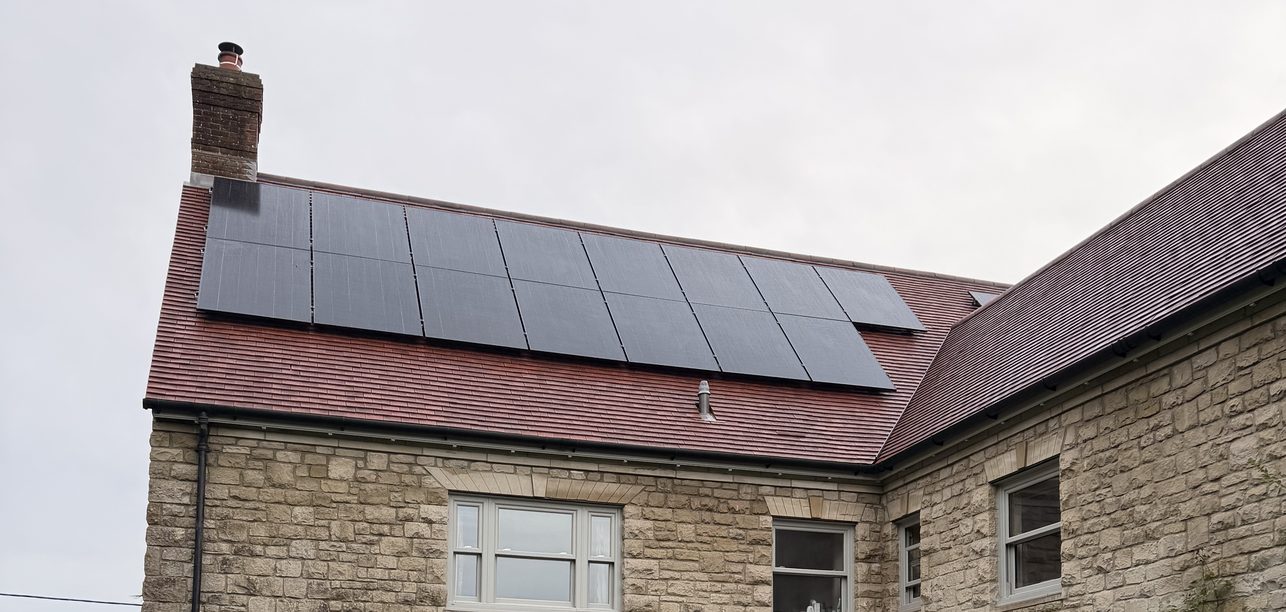 Solar panels on the roof of a stone house, installed by JellyWatt