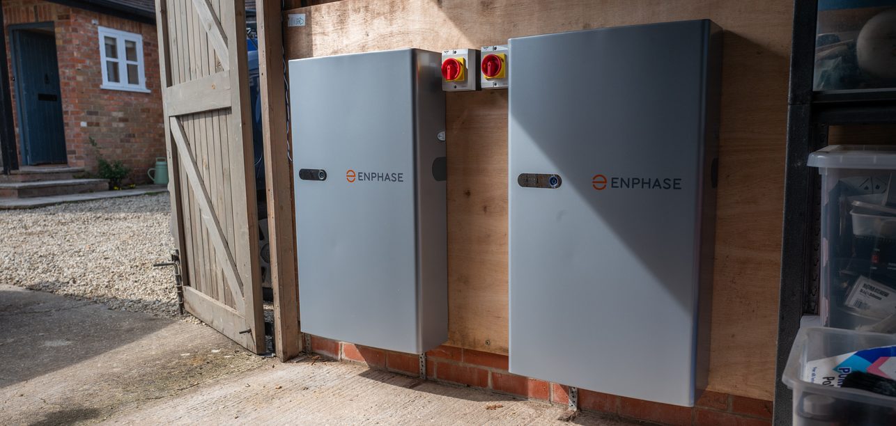 Two Enphase home batteries in a garage, installed by JellyWatt