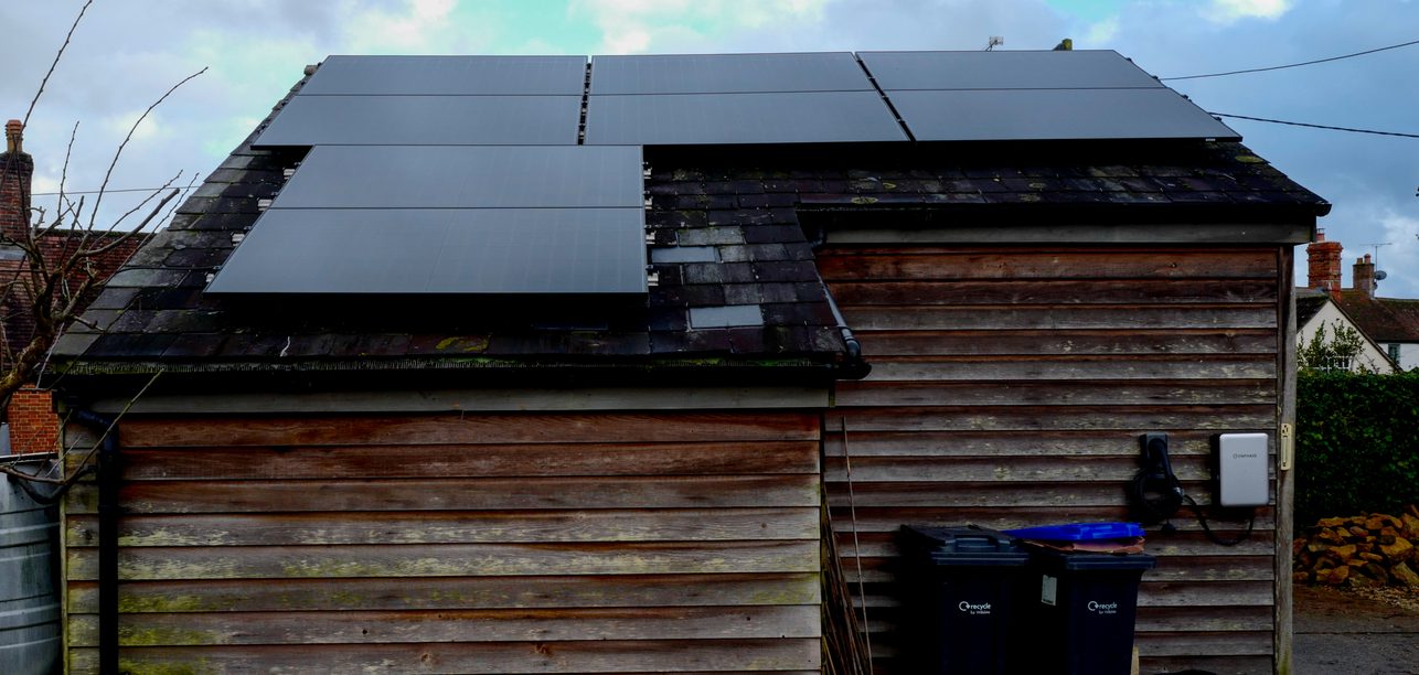 Black solar panels on a timber clad outbuilding, installed by JellyWatt