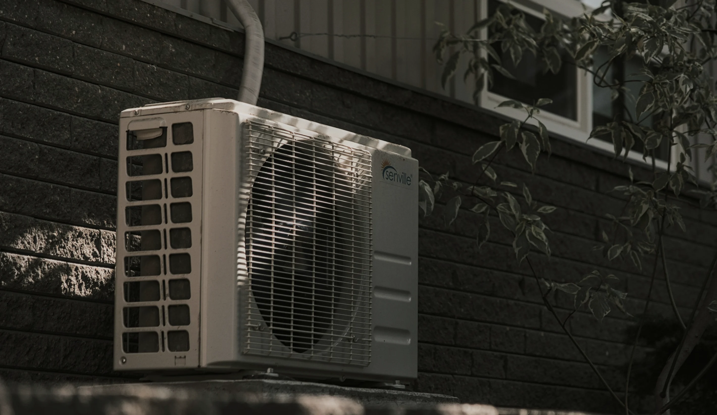Outdoor air conditioning unit against a dark wall